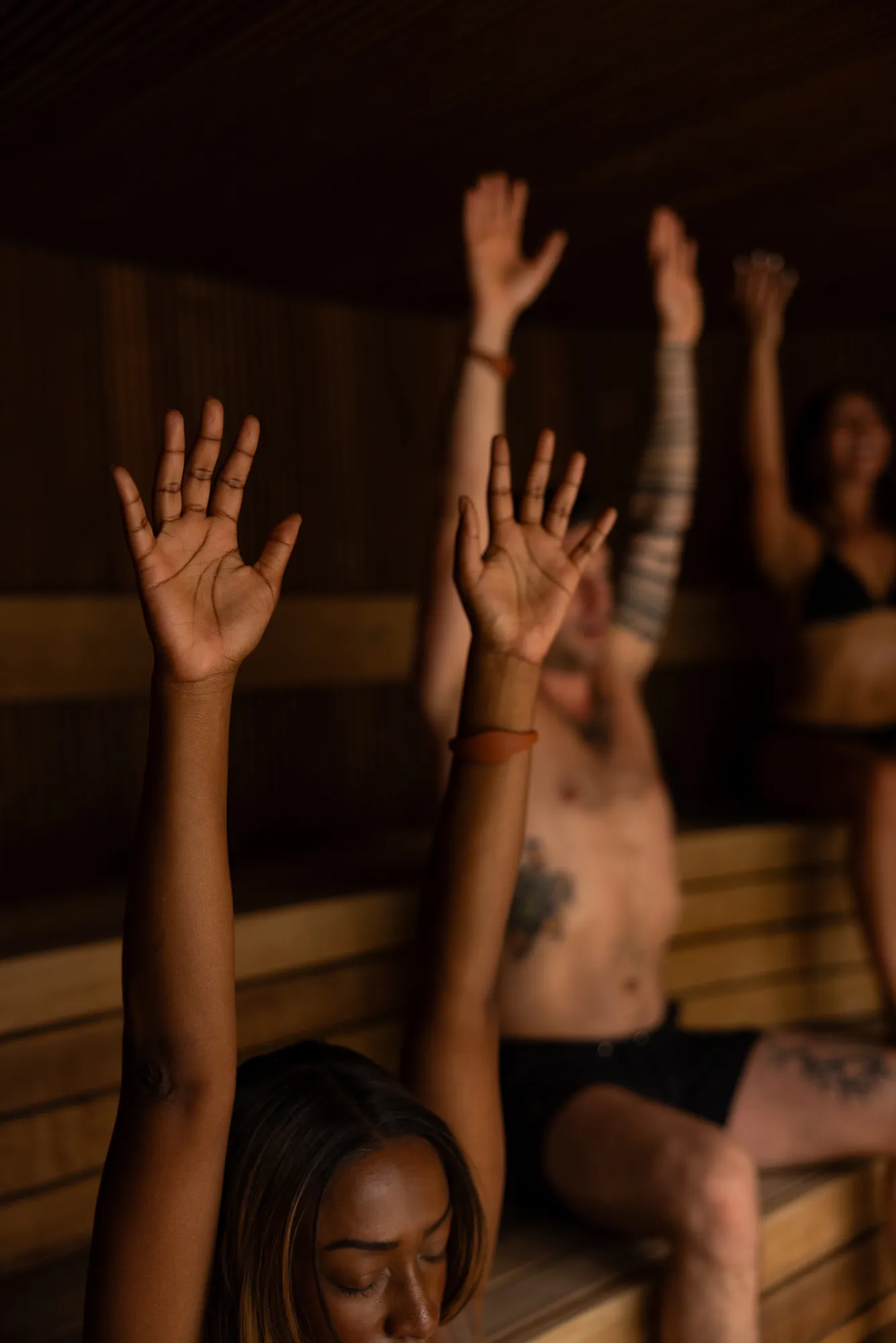 A group raising their arms during a guided sauna ritual